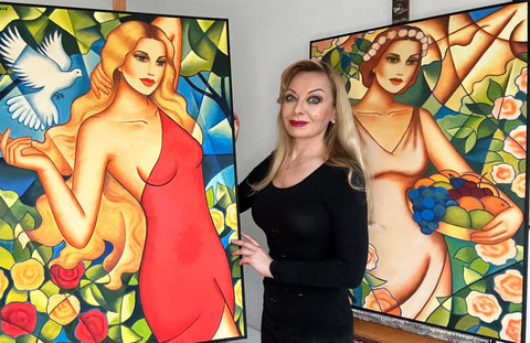 Künstlerin Ekaterina Moré mit zwei farbstarken Göttinnen-Bildern – Sinnbild weiblicher Stärke und Schönheit.