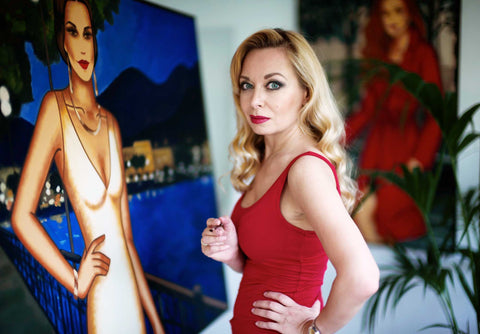 Ekaterina Moré im Atelier mit zwei emotionalen Frauenporträts im Feminine-Glamourism-Stil – sinnliche Kunst über weibliche Kraft.