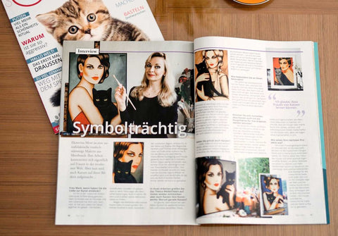 Künstlerportrait von Ekaterina Moré in der Zeitschrift Our Cats – Frauenporträt mit schwarzer Katze und leuchtenden Farben