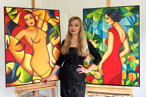 Ekaterina More vor ihren Bildern – stilisierte Frauenporträts als Ausdruck von Weiblichkeit, Intuition und innerer Stärke.