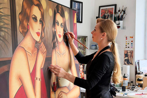 Ekaterina Moré in ihrem Atelier vor zwei Porträts – sinnliche Frauenkunst im Entstehungsprozess