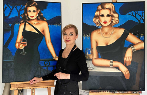 Ekaterina Moré im Atelier mit zwei Frauenporträts – Originalkunst als Wertanlage