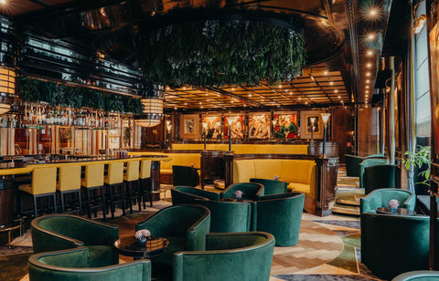 Bar26 im JW Marriott Hotel Berlin mit grünen Sesseln, gelben Sitzbänken und großformatigen Frauenbildern von Ekaterina Moré