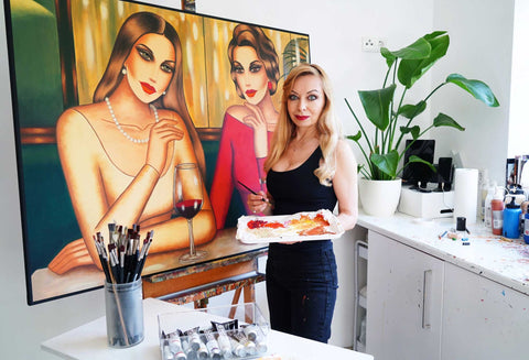 Ekaterina Moré in ihrem Atelier vor zwei Porträts – sinnliche Frauenkunst im Entstehungsprozess